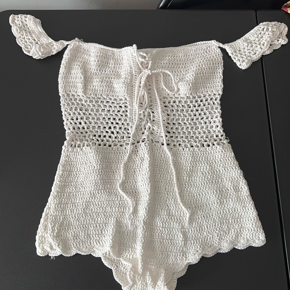 Knitted romper with draw string at chest.